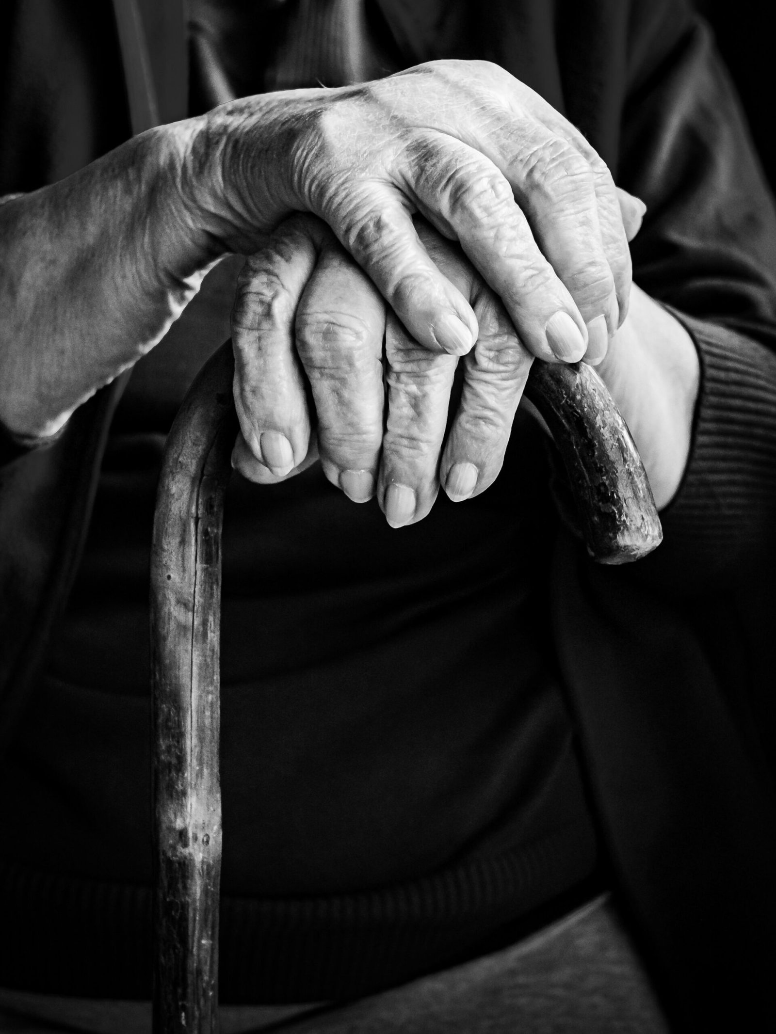 Care - elderly person with hands resting on cane